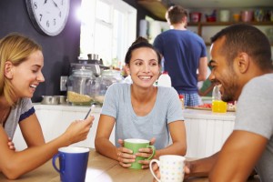 Group Of Friends Enjoying Breakfast In Kitchen Together