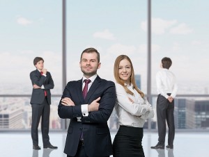 Happy young professionals are standing in a contemporary glass office in New York.