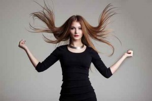 woman in black dress with bright makeup throws red hair