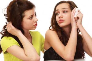 A young girl crying and a friend calming her, isolated on white