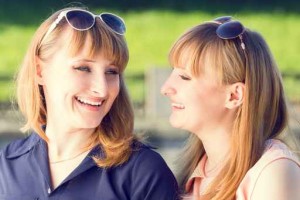 Young twins girls having fun laughing in summer park